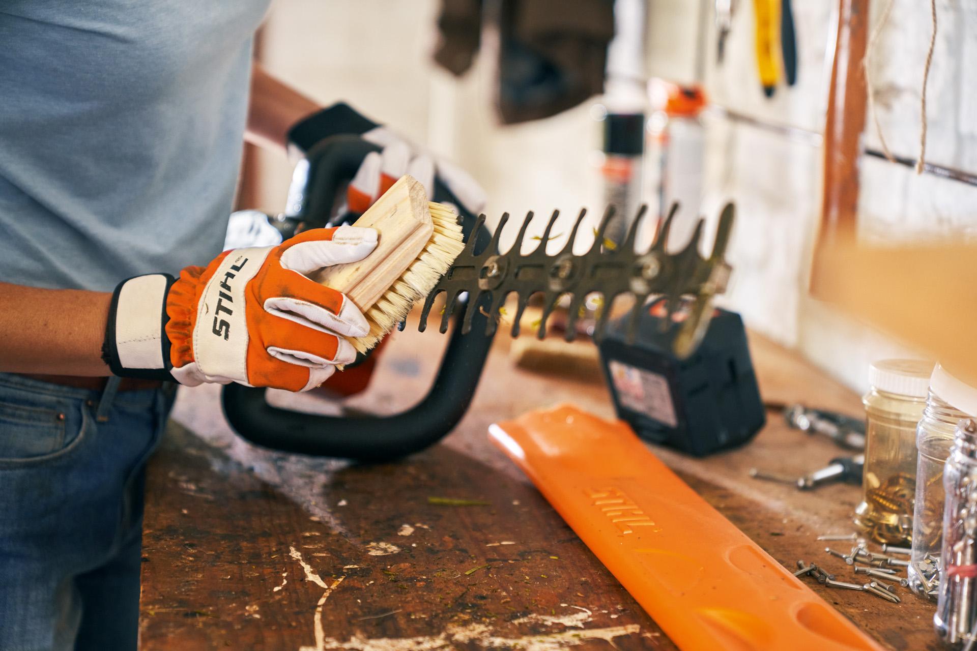 STIHL hedge trimmer being cleaned and maintained on a service bench